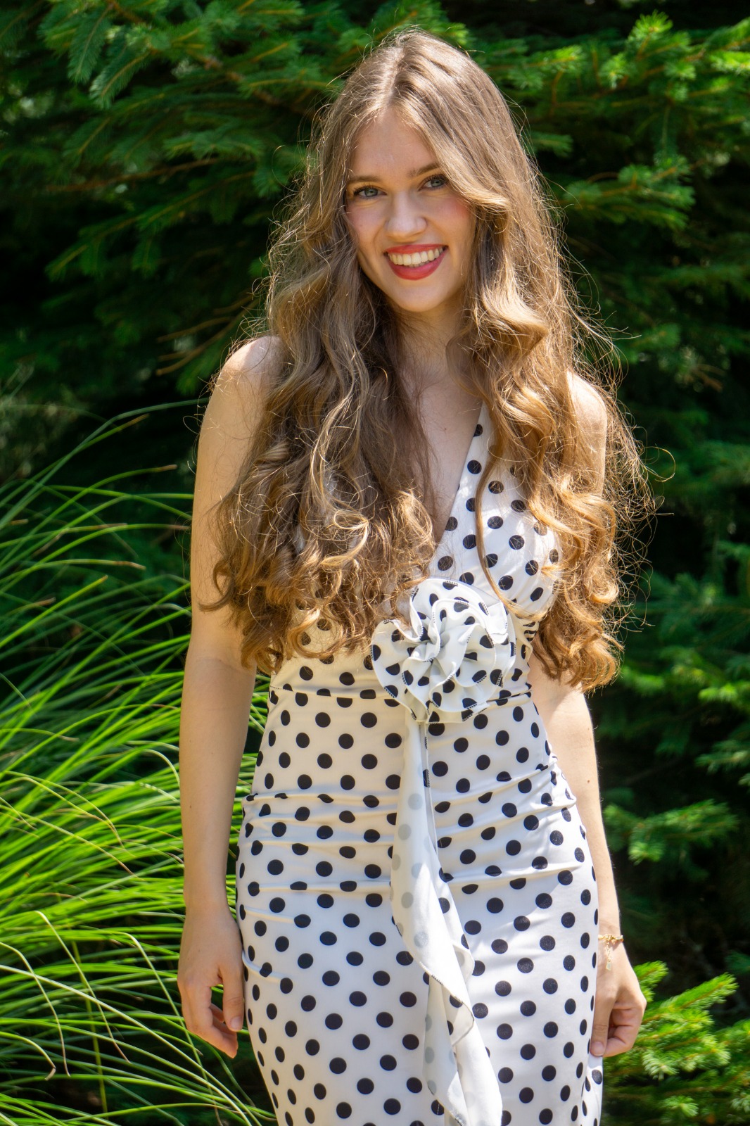 Girl in summer dress with green foliage in the background.